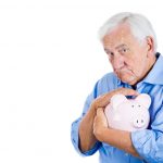 Old man holding, petting piggy bank. Financial decisions